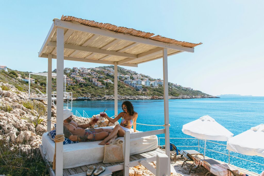 Couple enjoying drinks and lounging on luxury pool deck with ocean view
