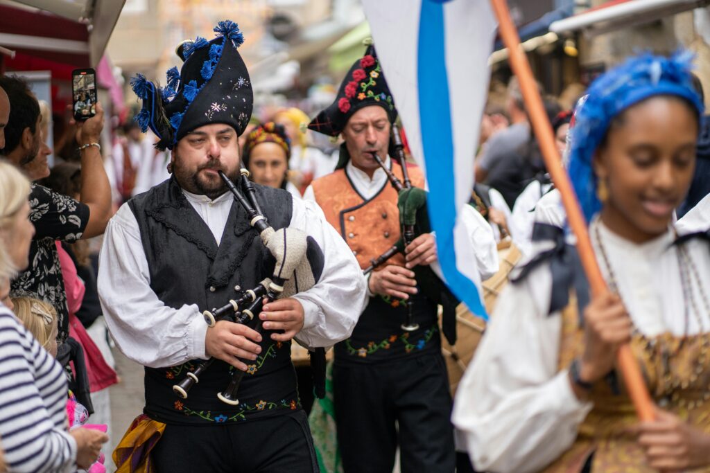 People in traditional Breton attire playing bagpipes during a cultural parade in France.